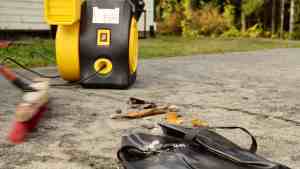 Airbag inflation blower and cleanup tools on a driveway.