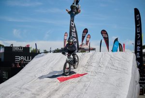 Mountain biker jumping onto Gravity Stunt Systems Mercury airbag during stunt show at Sea Otter 2025