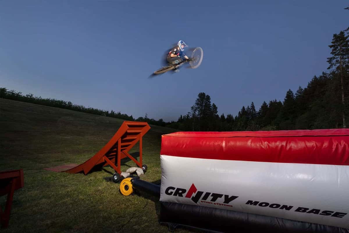 A Moon Base flat airbag in use for backyard mountain bike jumps at dusk