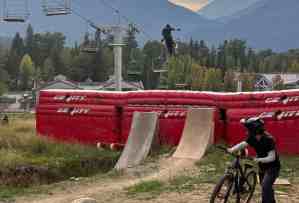 Two bikers enjoying the right bike ramp designs for their skill levels, against the setting sun in Whistler, BC